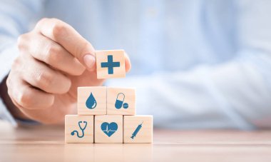 Hand arranging wood block with healthcare medical icon. Health insurance - concept.