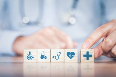 Hand arranging wood block with healthcare medical icon. Health insurance - concept.