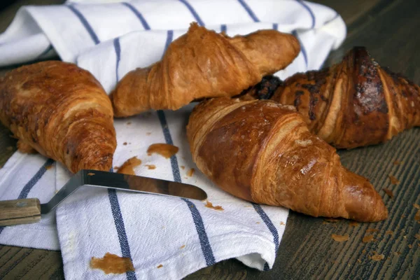 Smakfulle Croissanter Konditorkniv Som Ligger Stripete Håndkle Mot Trebord – stockfoto