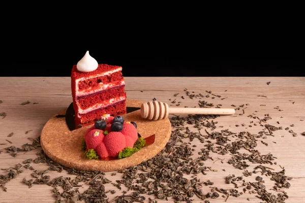 2つの食欲をそそるおいしい赤ケーキと蜂蜜のディップコルクスタンド木製の板の上に乾燥した緑のお茶を散乱 — ストック写真