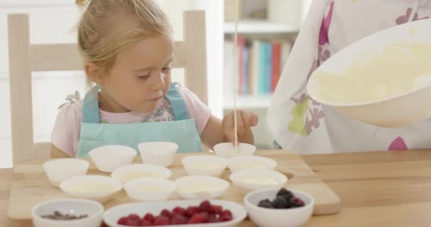 Skrattande flicka med muffinsformar och förälder i förkläde — Stockvideo