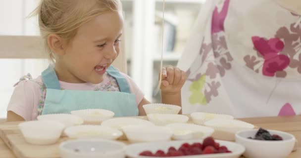 Gelukkig klein meisje met lege muffin houders — Stockvideo