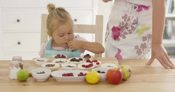 Nettes kleines Mädchen, das Beeren auf Muffins legt — Stockvideo