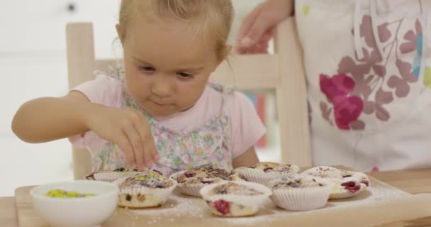 Close-up em menina ajudando a preparar muffins — Vídeo de Stock