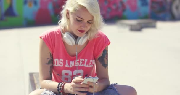Молодая женщина ищет мелодии на мобильном — стоковое видео