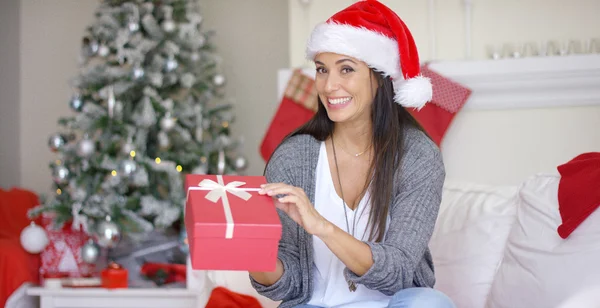 Eccitato giovane donna che apre un regalo di Natale — Foto Stock