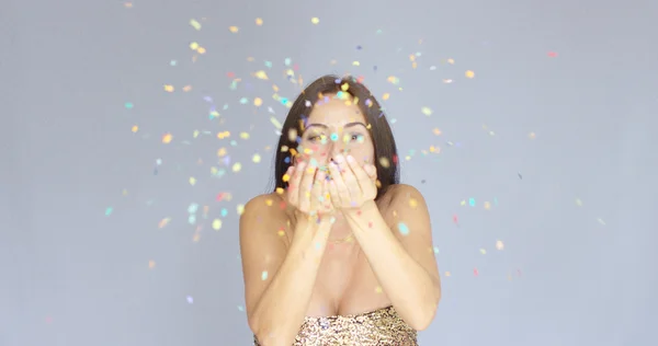 Jovem mulher soprando colorido Ano Novo confetti — Fotografia de Stock