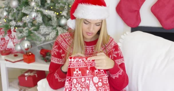 Ganska leende blondie titta inuti hennes julklapp — Stockvideo