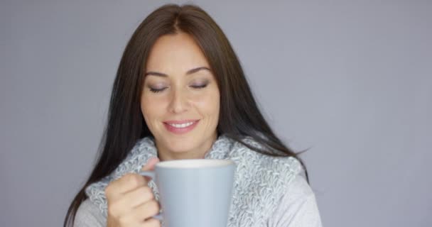 Hermosa mujer morena con una taza de bebida caliente — Vídeos de Stock