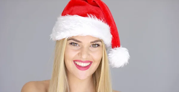 Красивая цыпочка в шляпе Санта-Клауса позирует с чувственной улыбкой — стоковое фото