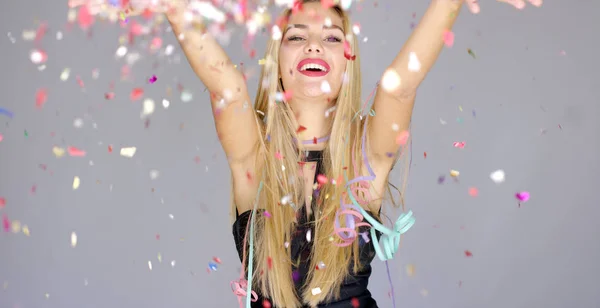 Sexig, blond flicka blåser konfetti till kamera riktning — Stockfoto