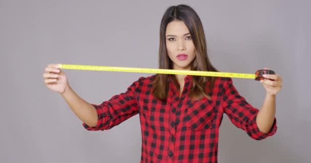 Beautiful female construction worker using measure tape — Stock Video