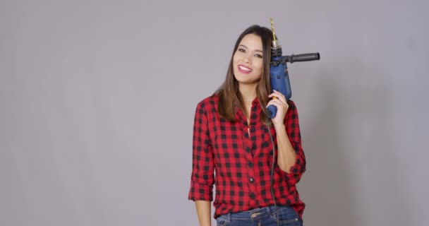 Capable young woman holding a power drill — Stock Video