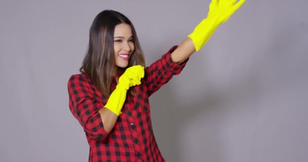 Junge Hausfrau zieht Gummihandschuhe an — Stockvideo