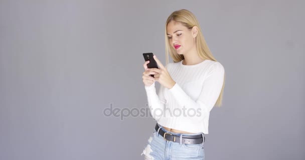 Trendiga unga blonda kvinnan kolla hennes mobil — Stockvideo