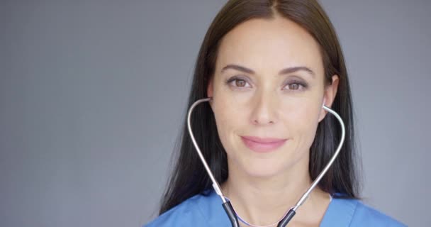 Attraktiv ung sjuksköterska använder ett stetoskop — Stockvideo