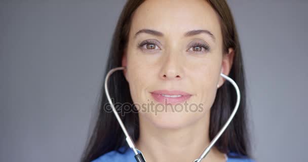 Aantrekkelijke jonge verpleegster met behulp van een stethoscoop — Stockvideo