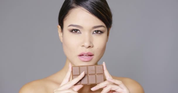 Mooie lachende vrouw bedrijf chocolade — Stockvideo