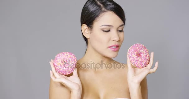 Donna ridente che tiene due ciambelle rosa agli occhi — Video Stock