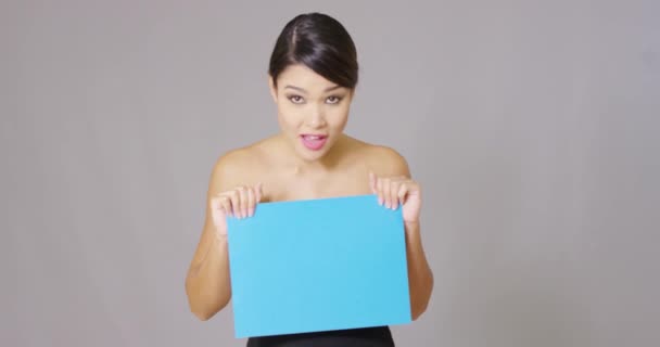 Junge Frau blickt auf blaue Karte herab — Stockvideo