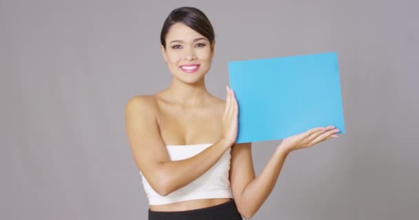 Счастливая женщина смотрит на синюю карточку в руках — стоковое видео