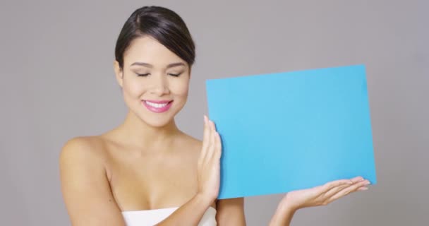 Happy woman looking at blue card in her hands — Stock Video