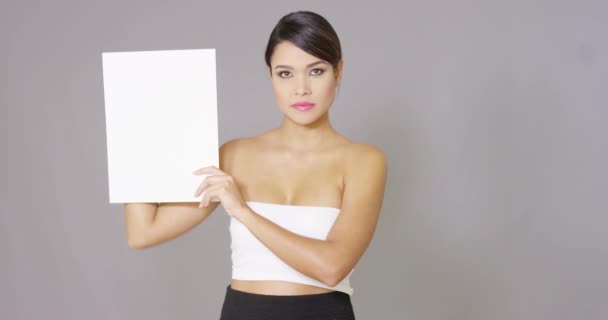 Улыбающаяся женщина смотрит на белую карточку в руке — стоковое видео