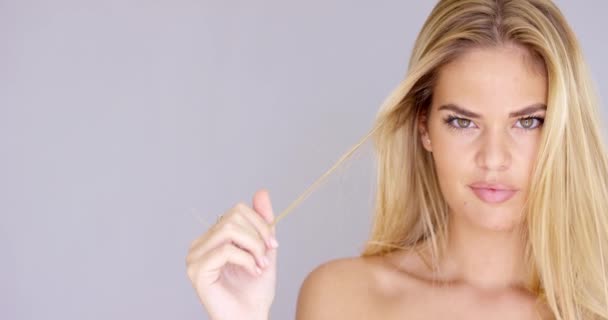 Verleidelijke blonde vrouw haar haren twirling — Stockvideo