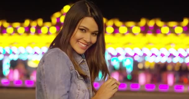 Усміхнена молода жінка на барвистому ярмарку — стокове відео