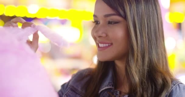 Jonge vrouw genieten van een hapje van candy floss — Stockvideo