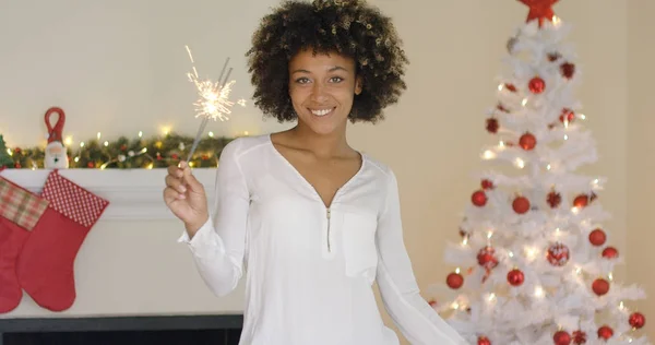 Mujer joven y bonita quemando un bengala de Navidad — Foto de Stock