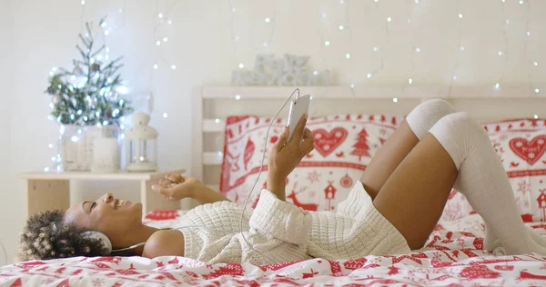 Jeune femme branchée écoutant de la musique de Noël — Photo