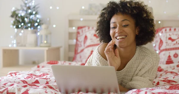 Красивая женщина в постели смеется над компьютером — стоковое фото