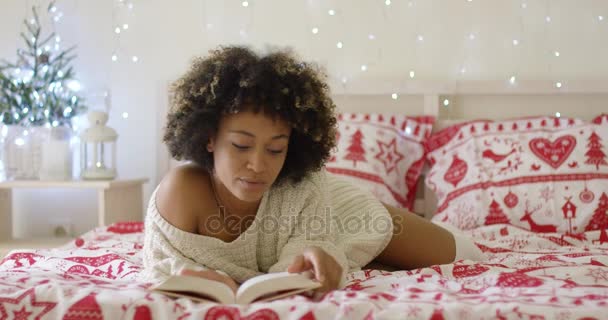 Calma hermosa mujer africana leyendo en la cama — Vídeo de stock