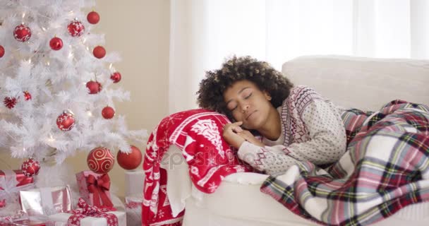 Mujer durmiendo en el sofá junto al árbol de Navidad — Vídeos de Stock