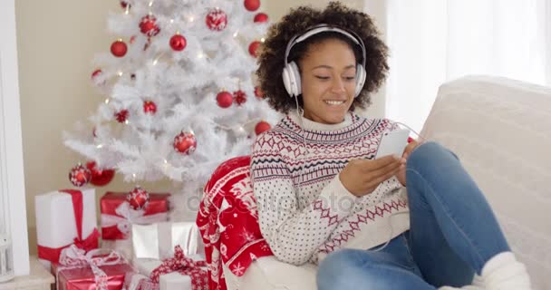 Mulher atraente ouvindo música no Natal — Vídeo de Stock