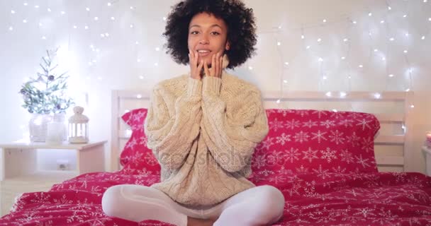 Smiling confident young woman sitting on her bed — Stock Video