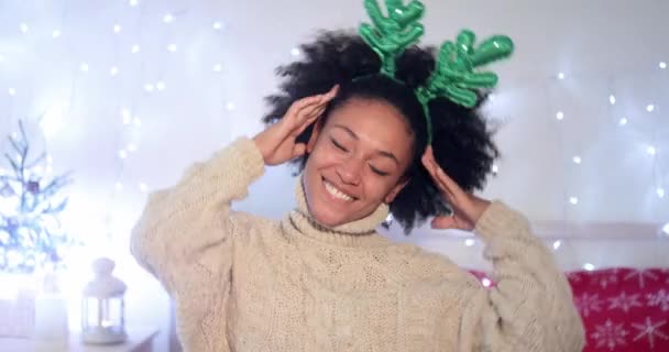 Playful young woman wearing green reindeer antlers — Stock Video