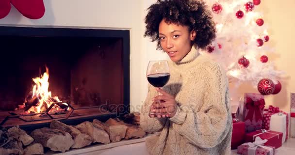Mujer bonita sostiene copa de vino junto a la chimenea — Vídeos de Stock