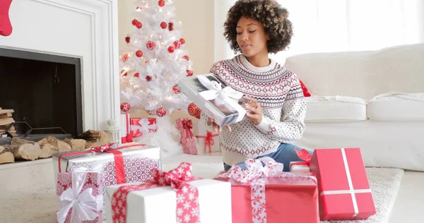 Leende ung kvinna öppna hennes presenter vid jul — Stockfoto