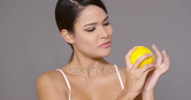 Linda mujer joven sosteniendo una naranja fresca a la mitad — Vídeo de stock