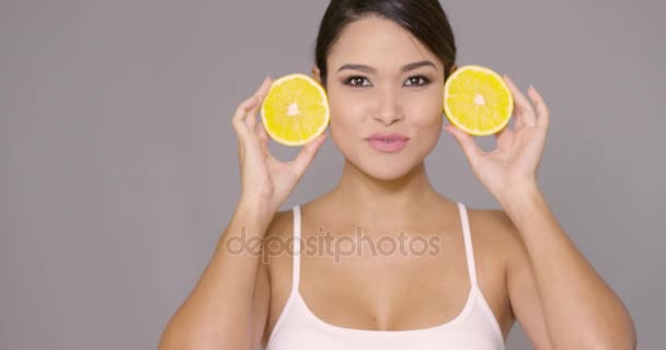 Gelukkig gezonde vrouw houden gesneden sinaasappelen — Stockvideo
