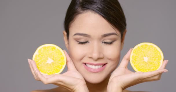 Красивая улыбающаяся женщина с лимонными половинками — стоковое видео