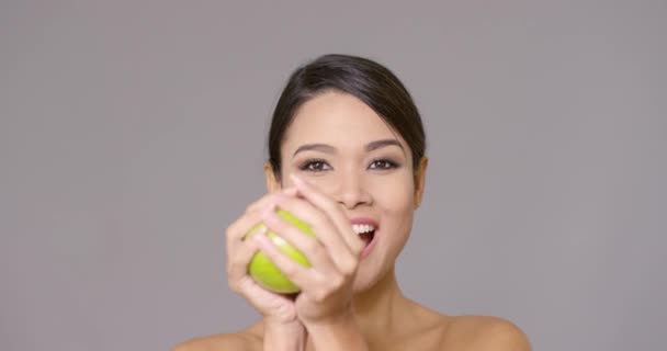 Lachen van gezonde jonge vrouw met een groene appel — Stockvideo