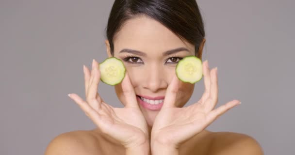 Grinning woman holding cucumber slices — Stock Video