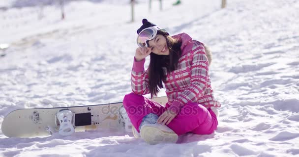 Молодая женщина на лыжном склоне с сноубордом — стоковое видео