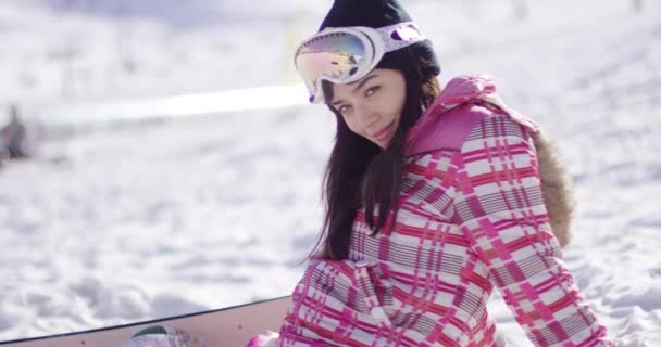 Hermosa asiático snowboarder sentado en la nieve — Vídeo de stock