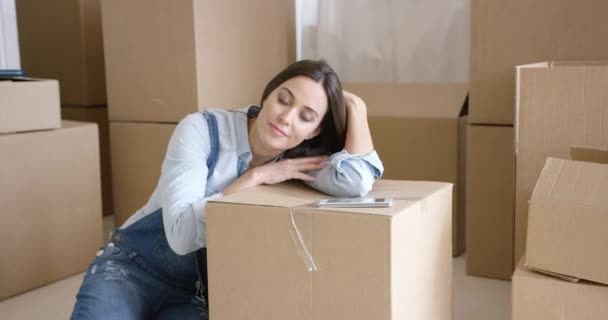 Mujer joven tomando una siesta en un cartón marrón — Vídeo de stock