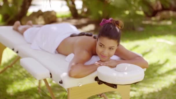 Glad ung kvinna med en hot stone-massage — Stockvideo