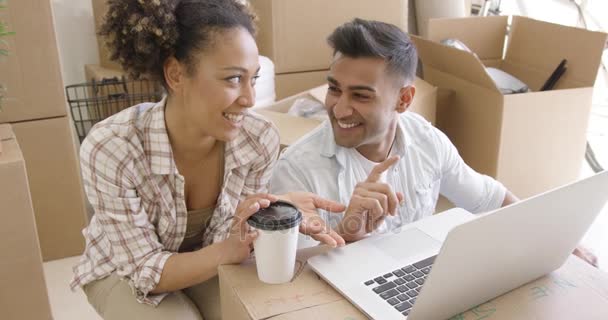 Pasangan ras campuran bahagia mendiskusikan saat menggunakan laptop — Stok Video